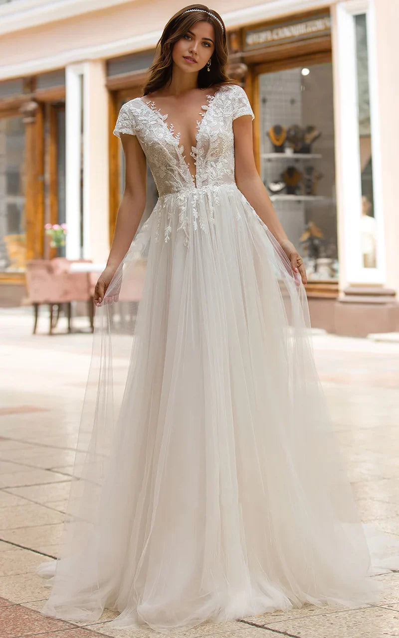 Vestido de novia de tul con cola larga, escote pronunciado y corte en A con apliques